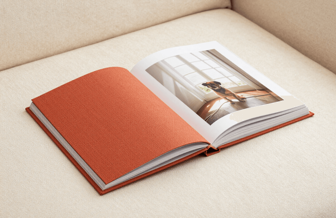 The printed life book, linen-bound, lying open on cream fabric